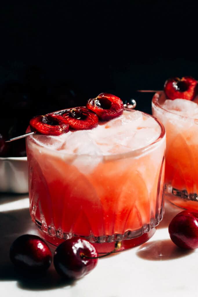a cherry margarita topped with fresh cherries