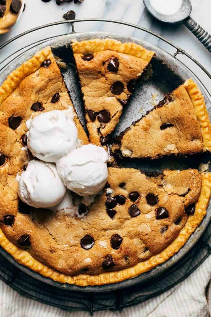 close up on the top of a sliced cookie pie with ice cream