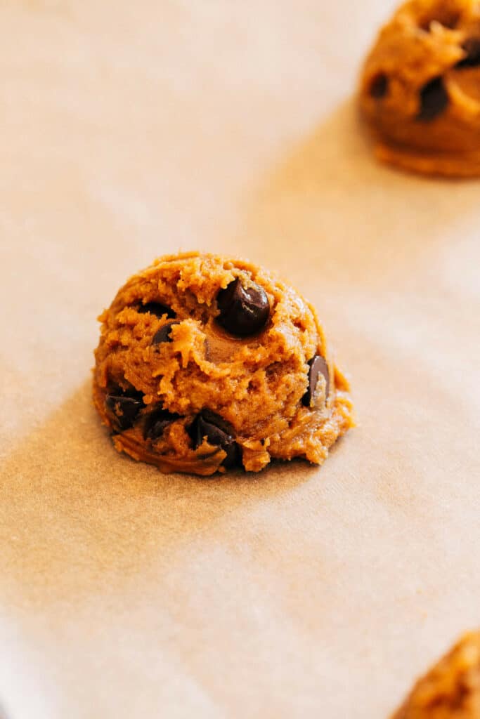 a scooped ball of pumpkin chocolate chip cookie dough
