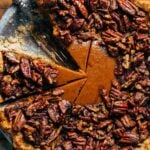 a sliced pumpkin pie topped with candied pecans
