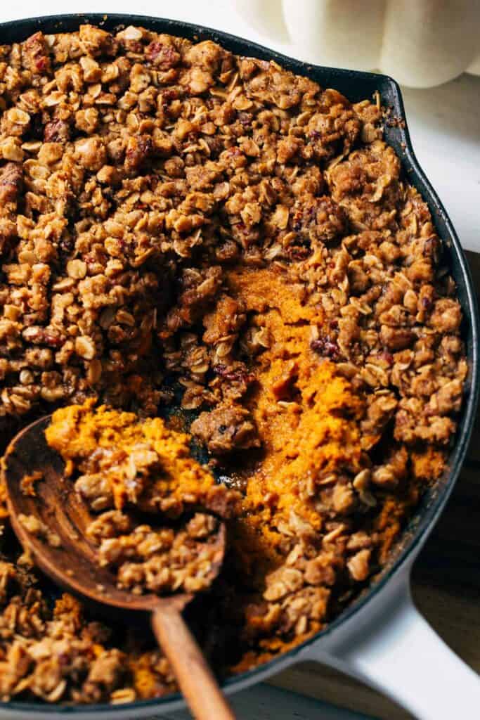 scooping pumpkin crisp out of a skillet