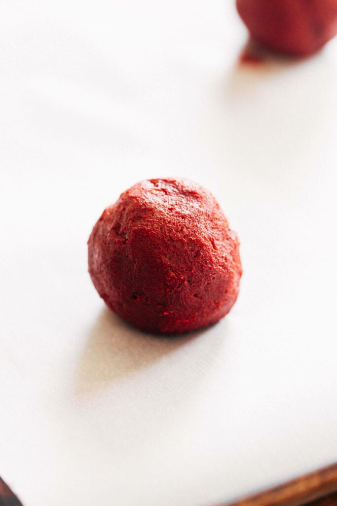 a ball of red velvet cookie dough filled with chocolate