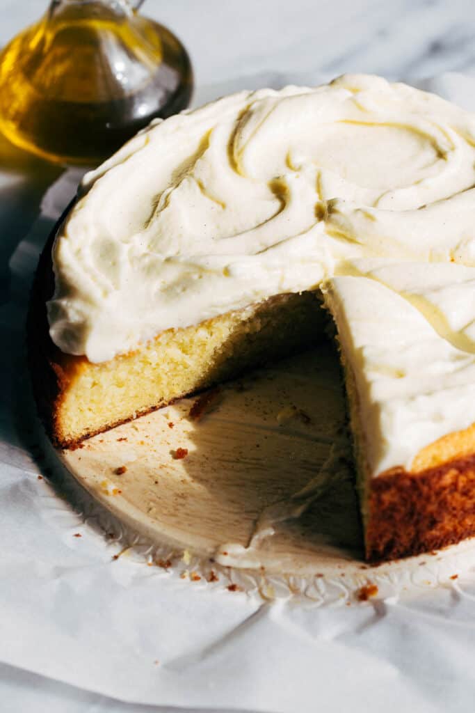 a sliced olive oil cake with mascarpone frosting