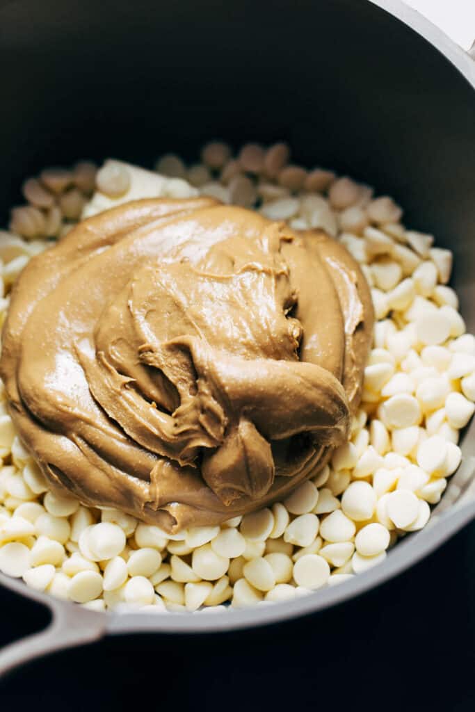 a saucepan with white chocolate chips, butter, and sunflower seed butter