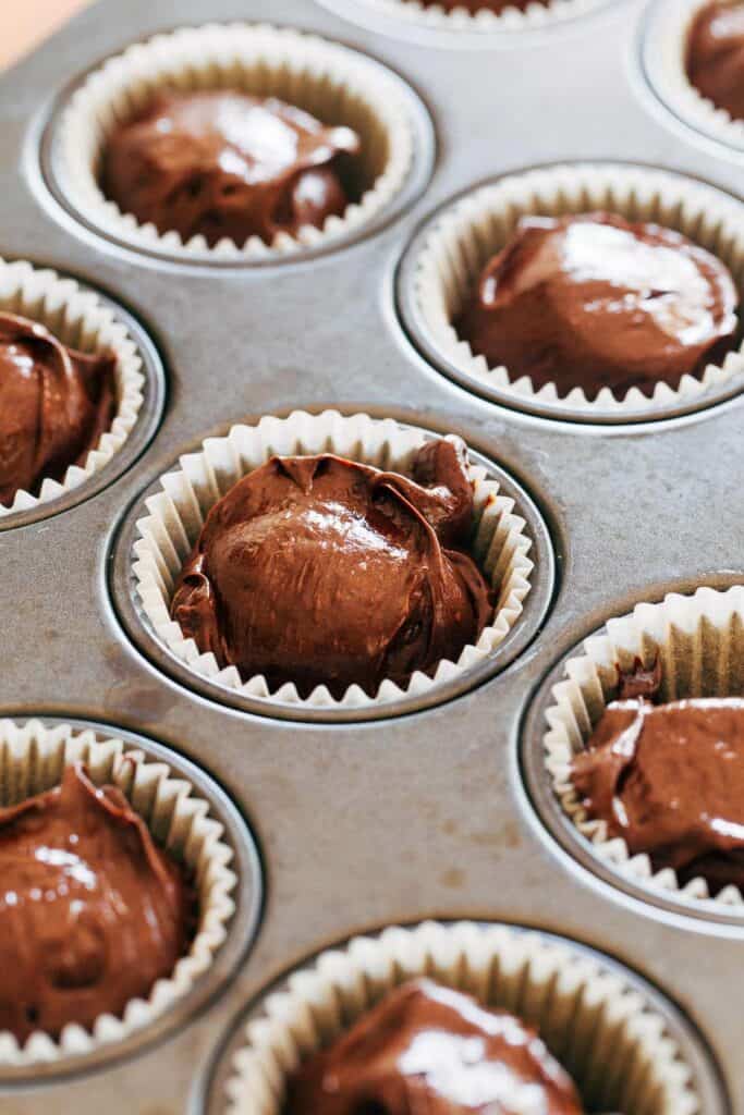 dollops of flourless chocolate cake batter in a muffin pan
