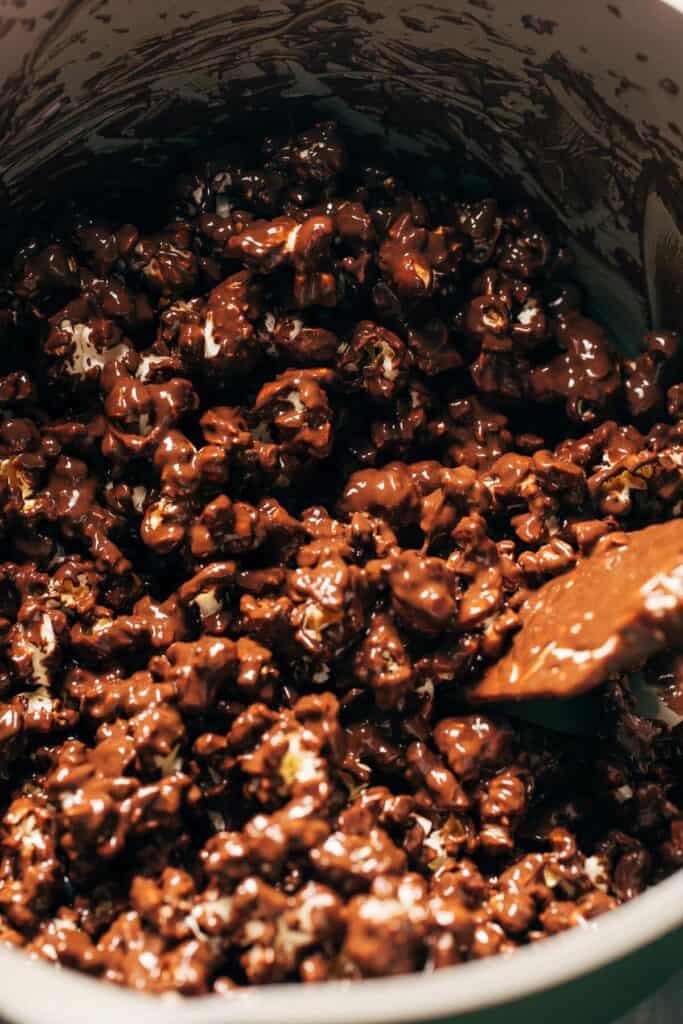 process shot of chocolate coated popcorn being mixed in a bowl