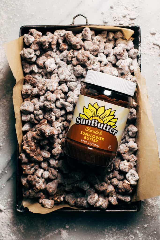 pan of double chocolate puppy chow with a jar of sunbutter on top