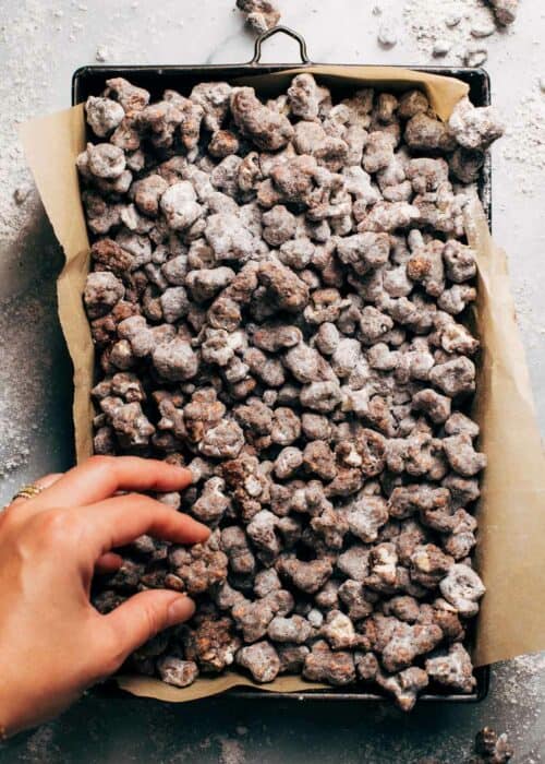 hand grabbing a handful of double chocolate popcorn puppy chow