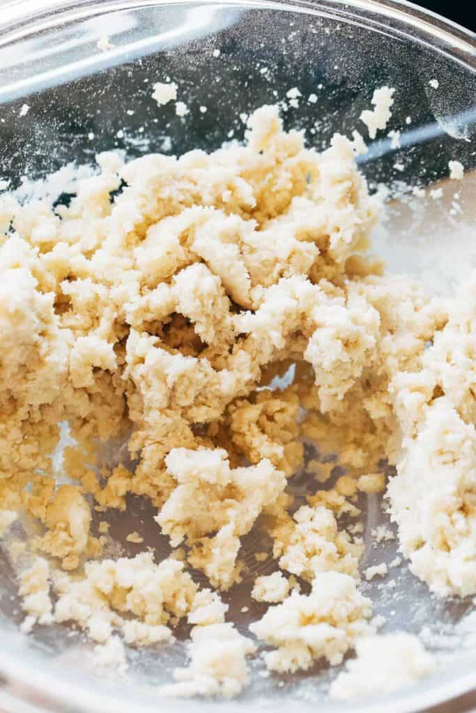 process shot of crumbled shortbread dough in a bowl