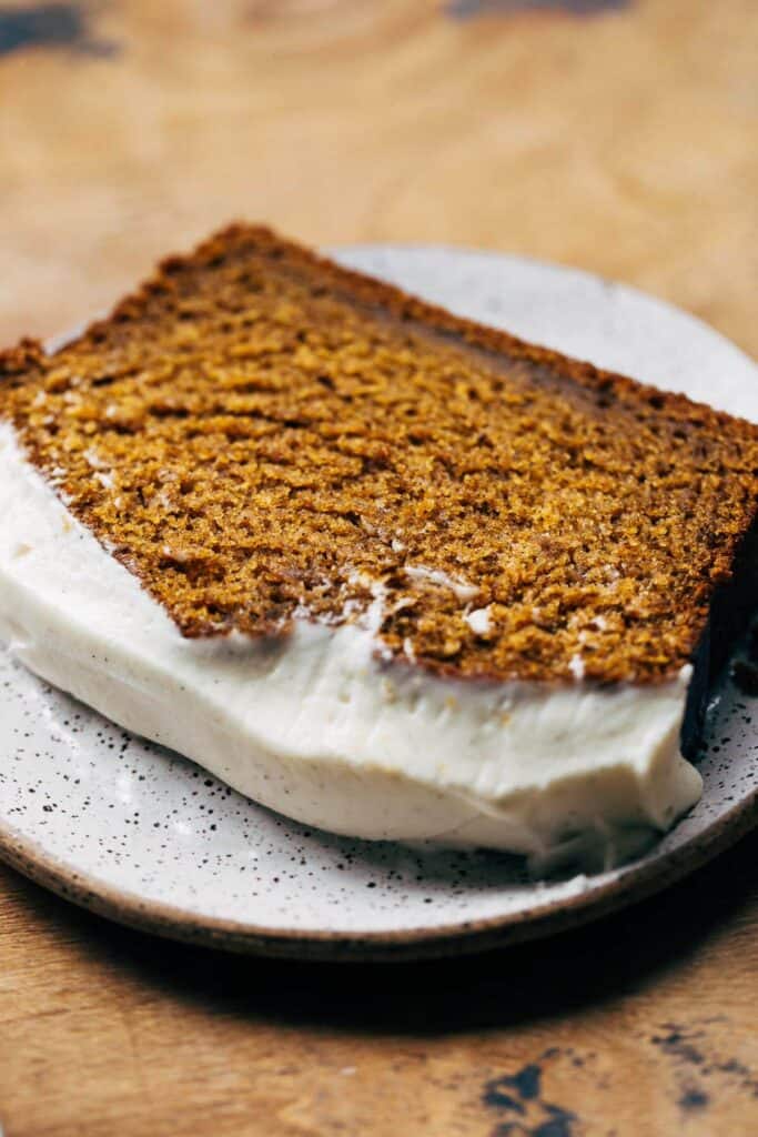 close up on slice of cream cheese frosted pumpkin bread