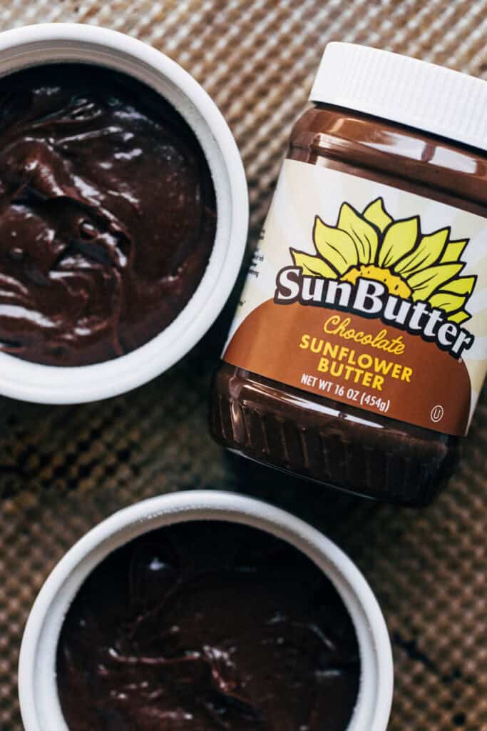 two chocolate filled ramekins with a jar of sunbutter