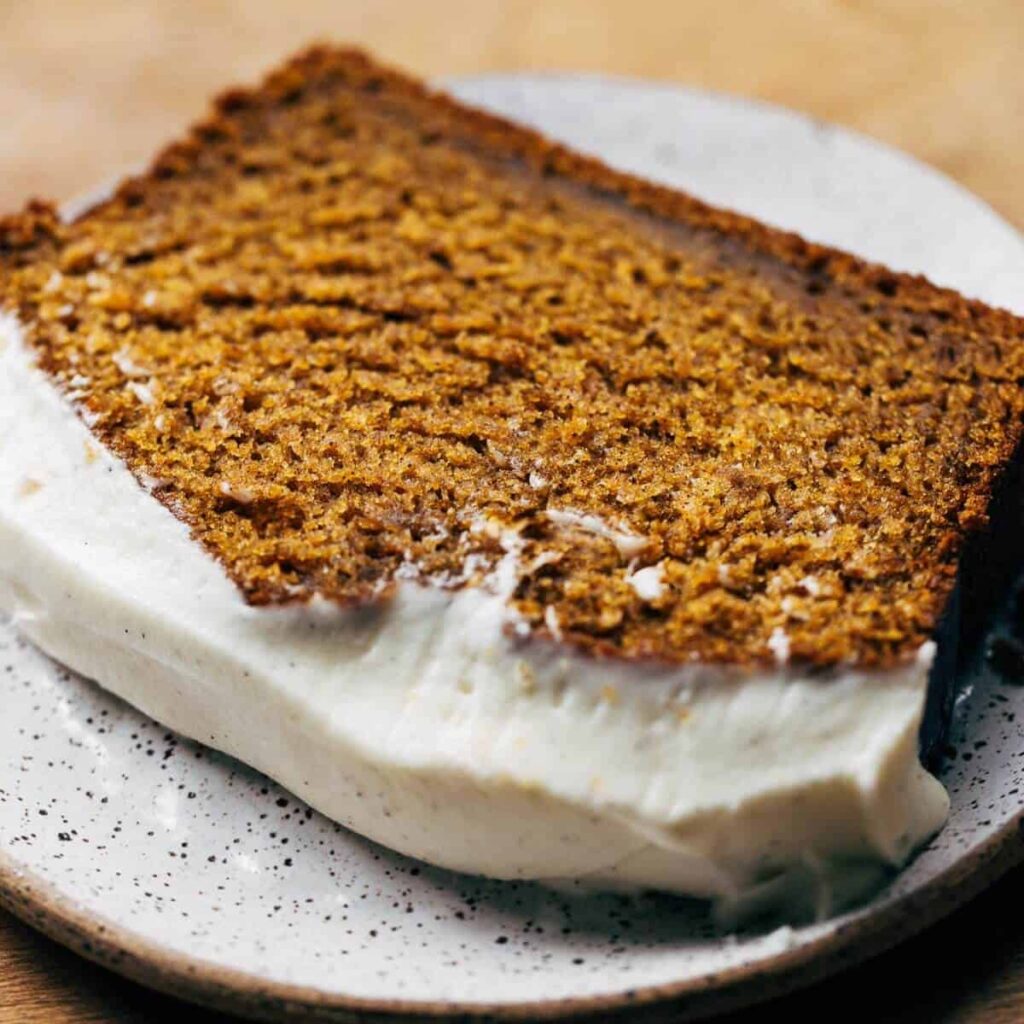 close up on slice of cream cheese frosted pumpkin bread