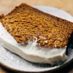 close up on slice of cream cheese frosted pumpkin bread