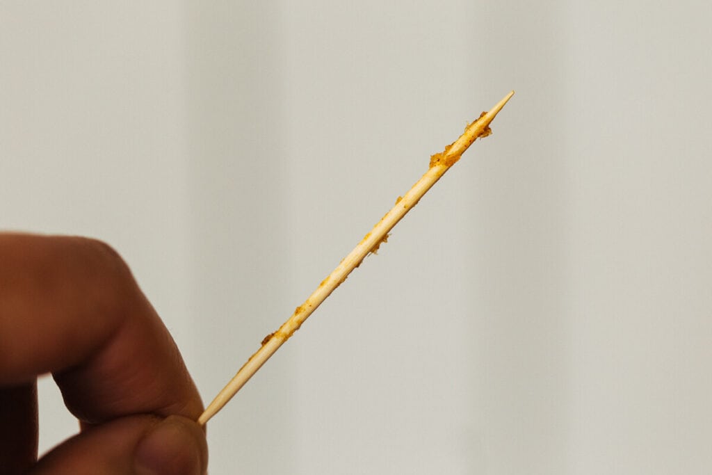 close up on toothpick test for pumpkin bread