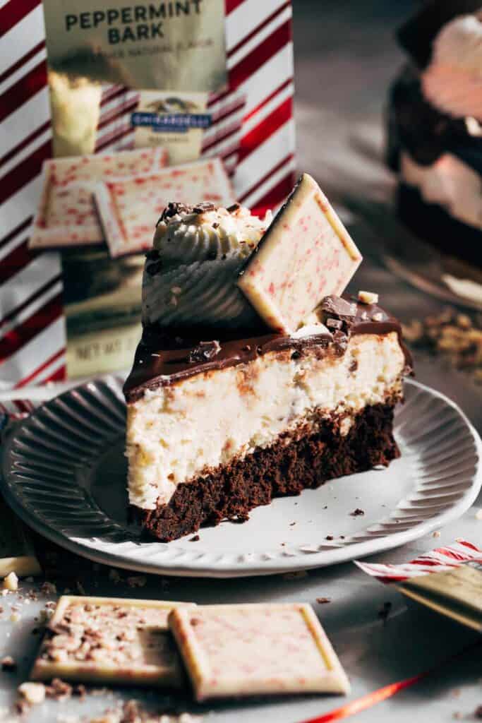 slice of peppermint bark mousse cake topped with peppermint chocolate square