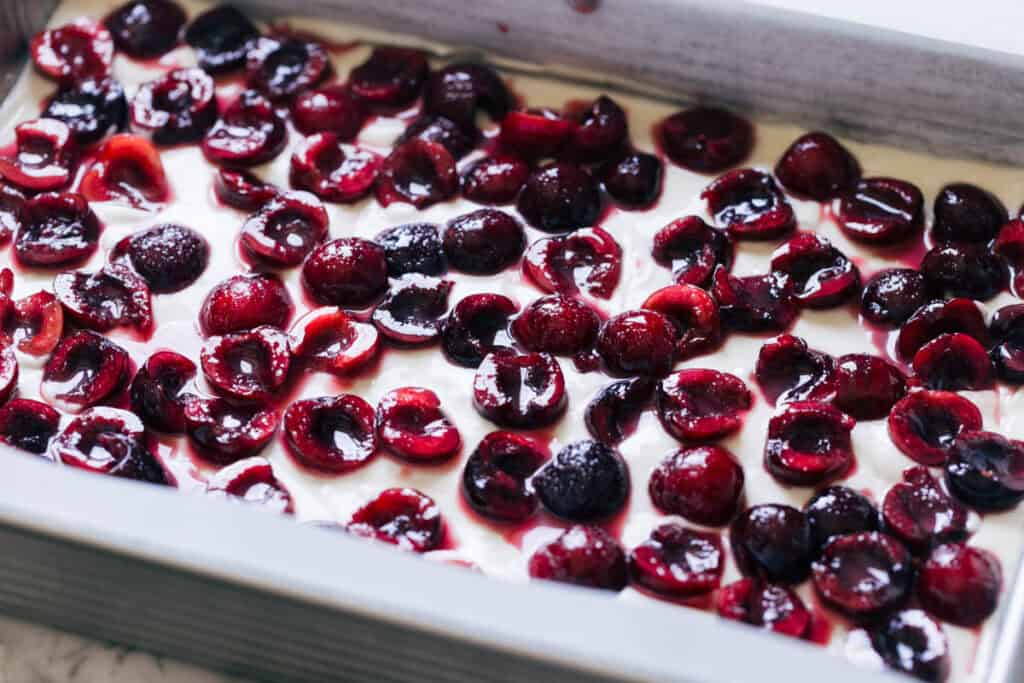 Barres de cheesecake aux cerises fraîches - Walnut Bakery 4 Répartir des cerises fraîches sur une couche de mélange de cheesecake