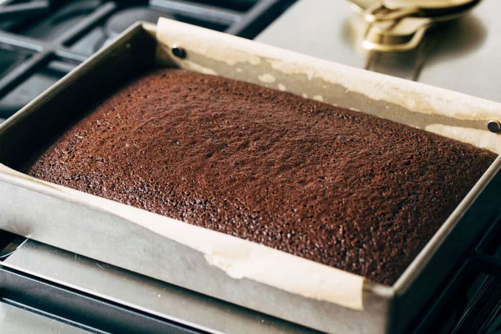 process shot of baked chocolate sheet cake in a pan