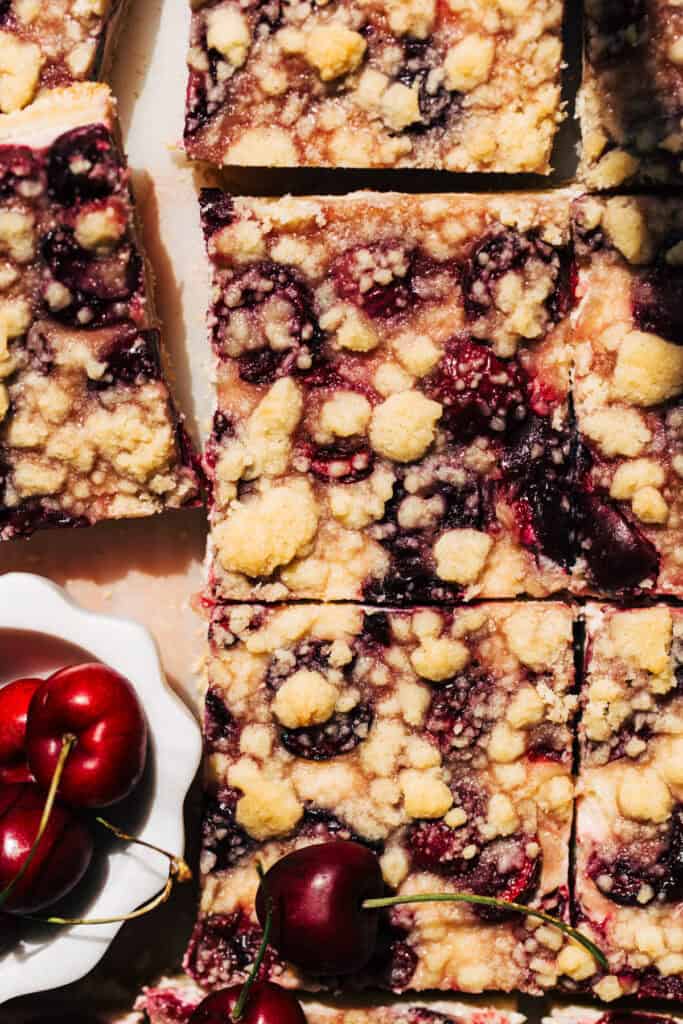 Barres de cheesecake aux cerises fraîches - Walnut Bakery 7 Garnir les barres de cheesecake aux cerises fraîches d'une garniture crumble