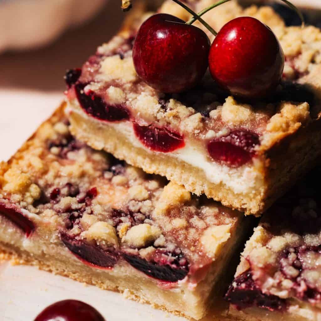 a stack of fresh cherry cheesecake bars