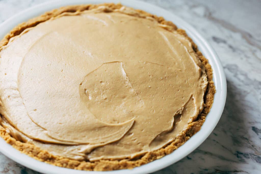 process shot of no bake peanut butter pie filling in crust