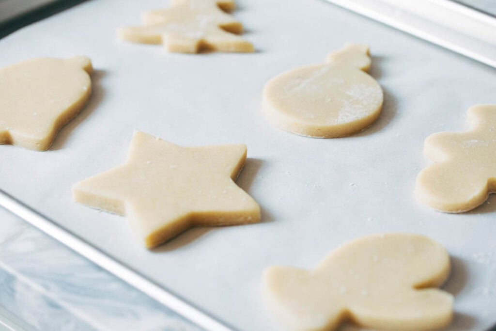 process shot of cut out sugar cookie dough on baking sheet