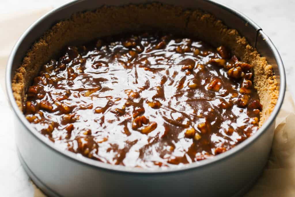 process shot of pecan pie filling in cheesecake crust