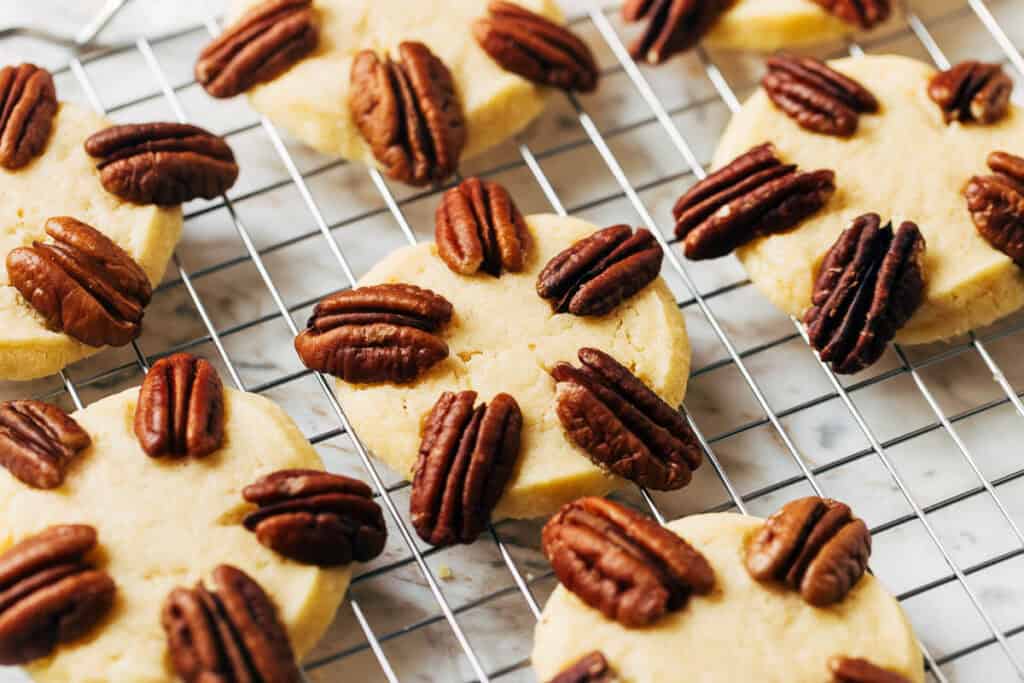 process shot of pecans on baked shortbread cookie