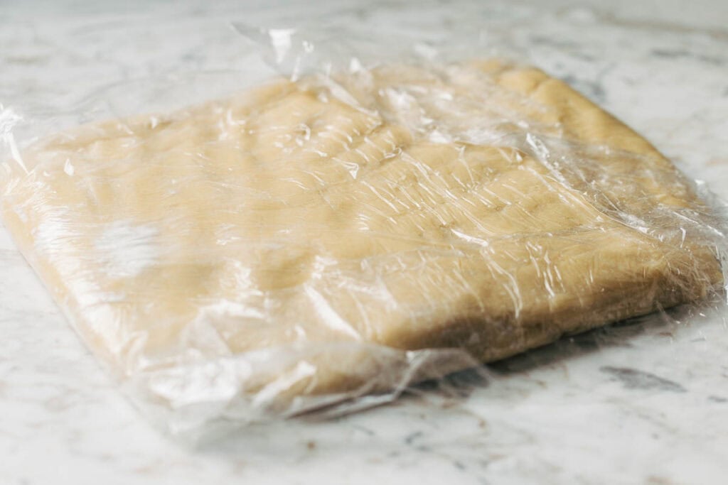 process shot of sugar cookie dough wrapped in plastic wrap