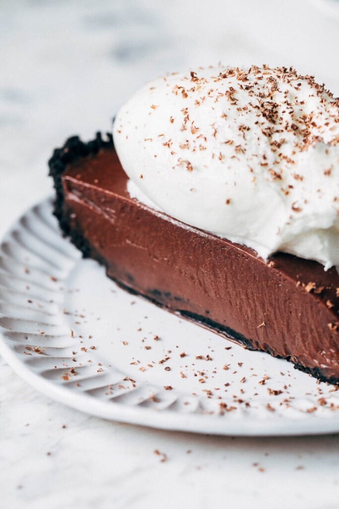 close up on chocolate pie slice topped with whipped cream