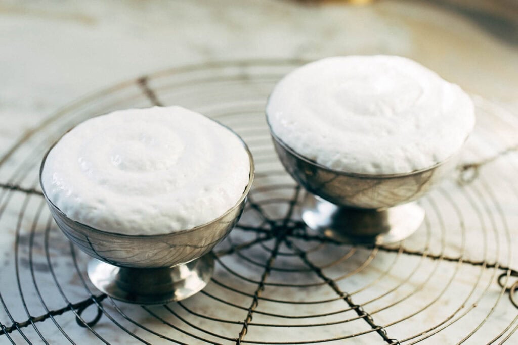 process shot of marshmallow fluff topped on lava cakes in ramekins