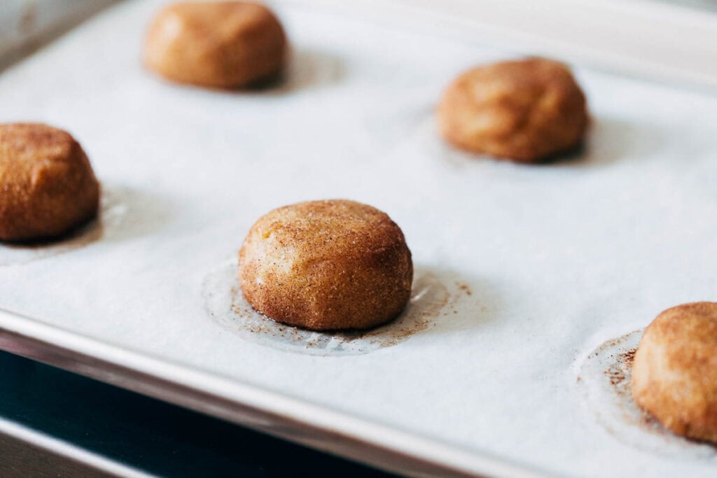 process shot of snickerdoodle cookie dough on a baking sheet