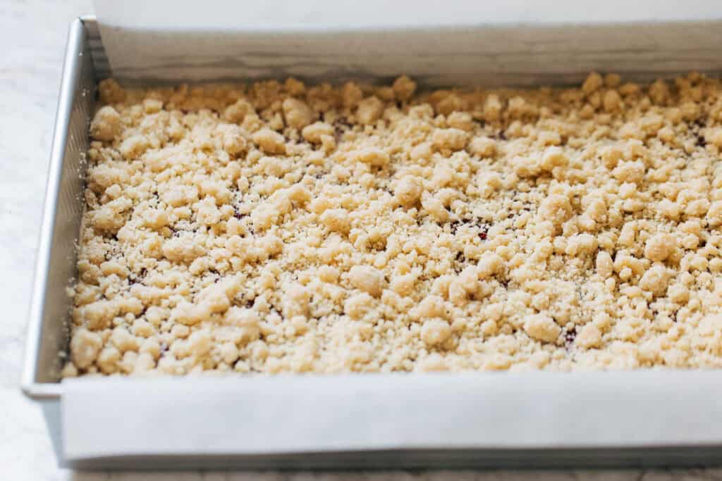 process shot of raspberry cheesecake crumble bars before baking