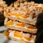 close up on stacked peach cheesecake bars