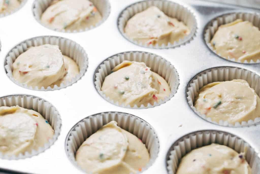 process shot of funfetti batter in muffin pan